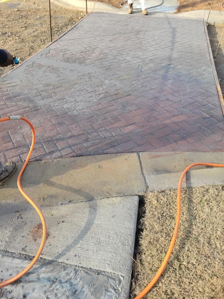 Close-up detail of stamped concrete herringbone brick pattern and color - JSW Construction